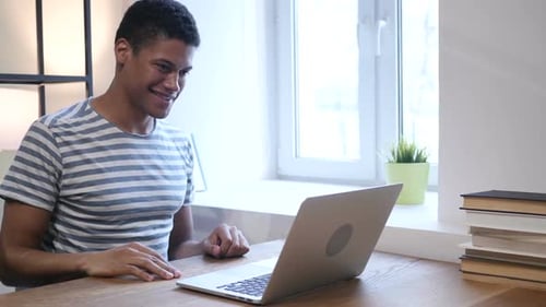 Smiling Man Video Calling on Laptop at Home