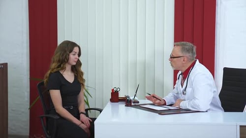Female patient is sitting at doctor`s office. Cute patient is listening carefully to medic`s adviсe.