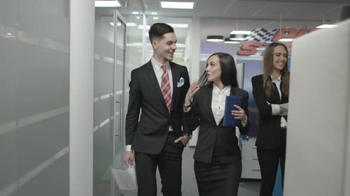Smiling Colleagues Walking and Talking in an Office