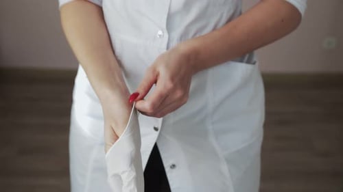 Woman in Coat Puts on Medical Gloves