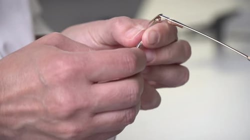 Person Repairing Frames of Glasses With Small Tool