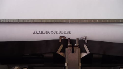 Typing alphabet letters A B C D E on retro typewriter. Close up.