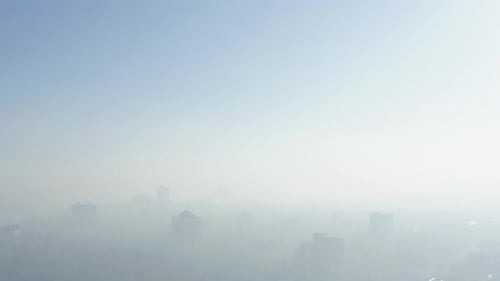 Morgen mit dichtem Nebel in der Stadtantenne. Konzept der Luftverschmutzung