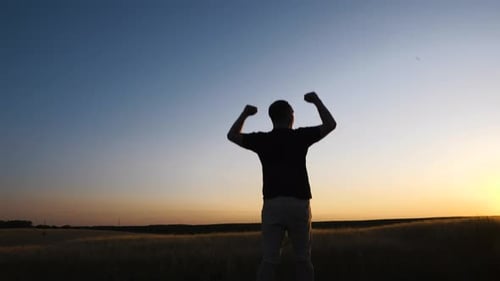 Man Silhouette Raising Arms at Golden Sunset