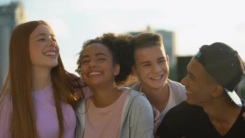 Smiling Teens Huddle Together in Urban Setting