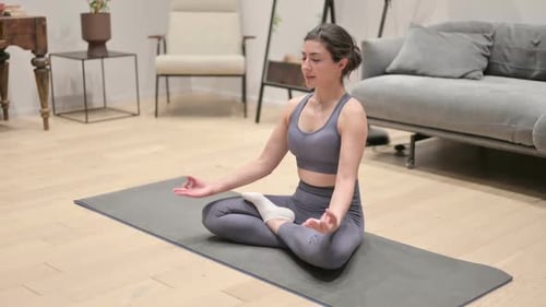 Peaceful Indian Woman Meditating on Yoga Mat at Home