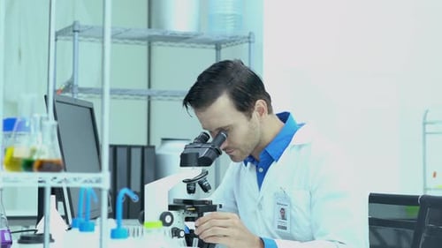 Homme scientifique regardant au microscope