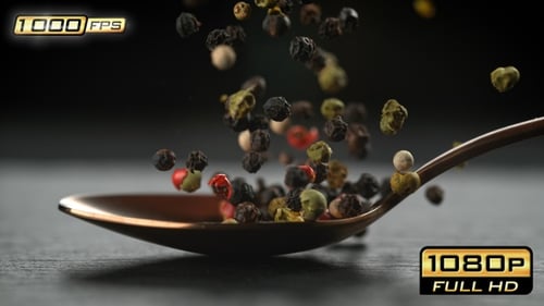 Colorful Peppercorns Falling onto Spoon in Slow Motion