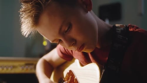 Young Boy Plays Electric Guitar in Studio