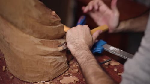 Woodcarver Carefully Chiseling Detailed Wooden Sculpture