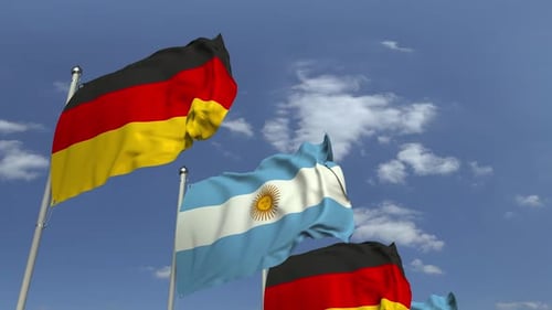Waving Flags of Argentina and Germany Against Blue Sky
