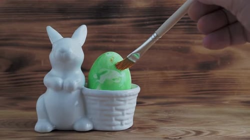 Painting Decorative Easter Egg Next to Bunny Rabbit