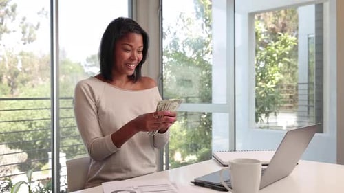 Mixed ethnicity woman working from home on her laptop