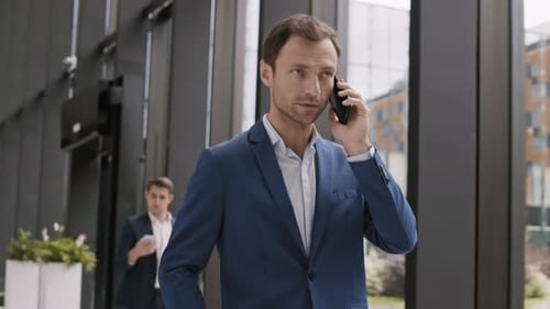 Businessman Going along Office and Talking on Phone