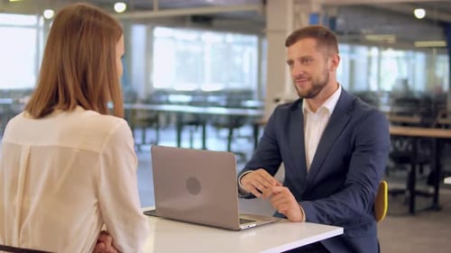 Man and Woman Meeting at Table With Laptop