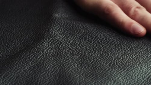 Hand Touches Black Textured Surface