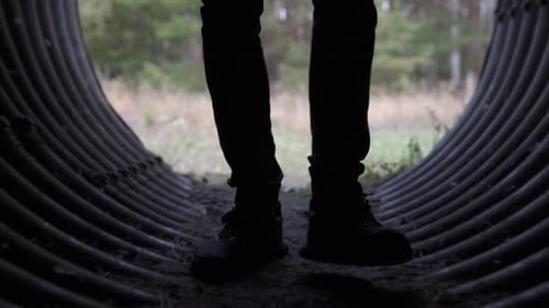 A man walks on an underground round concrete rain collector.