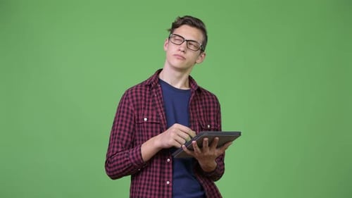Teen Boy Using Tablet Against Green Background