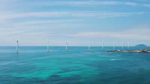 Wind turbines lined up over the sea. Sea and sky scenery. Jeju island