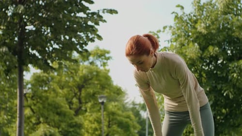 Athletic Woman Resting in Urban Park after Workout