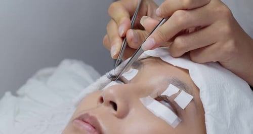 Woman having eye lash extension process