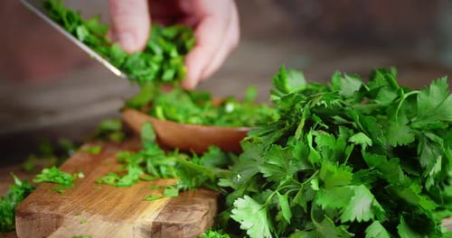 Fresh Parsley Minced With Knife on Wooden Board