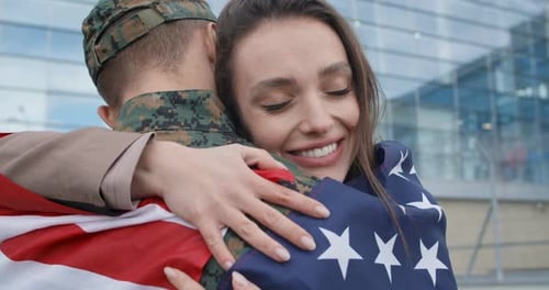 Woman Hugs Soldier with American Flag
