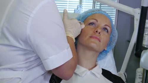 Hands of Cosmetologist Making Injection in Face