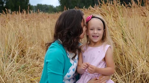 Mother and Daughter Sit in a Wheat Field