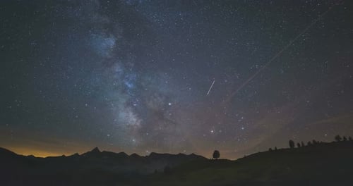 Time Lapse de la Vía Láctea y las estrellas en el cielo nocturno de verano que giran sobre los Alpes