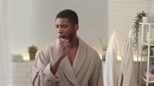 Man Brushing Teeth in Bright Modern Bathroom