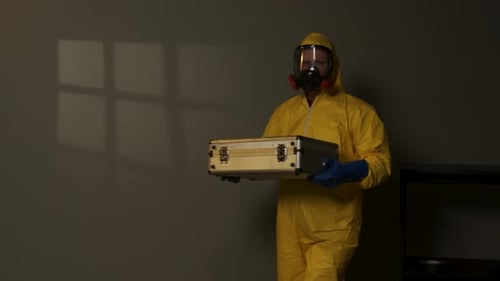 Hazmat suit-wearing man explores a smoky room