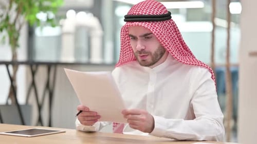 Upset Arab Businessman Having Loss on Documents in Office