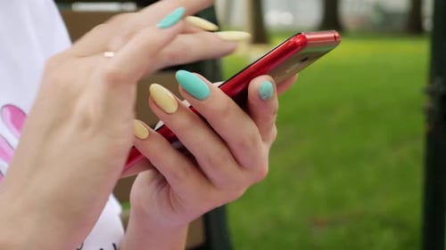 Woman Using App on Mobile Phone in City Park