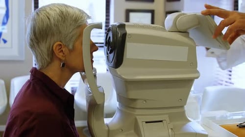Woman Having Eye Exam with Optometry Machine