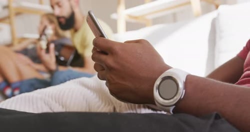 Adult Using Mobile Phone with Friends in Background