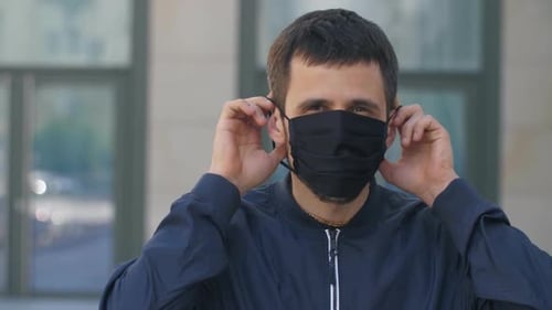 Man Puts On Protective Face Mask Outdoors