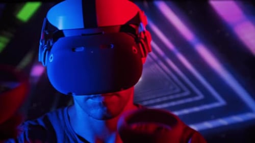 Man Wearing VR Headset Illuminated by Neon Lights