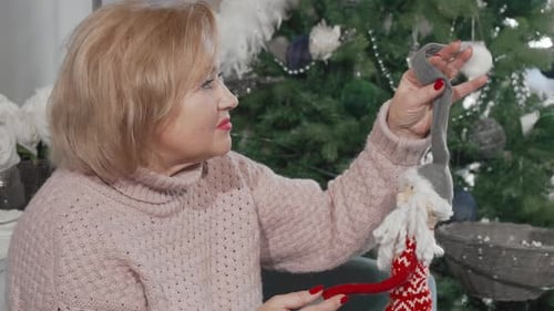 Senior Woman Smiles at Christmas Doll Ornament