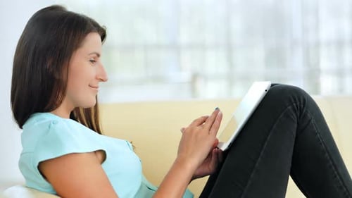 Young Woman Relaxing at Home with a Tablet