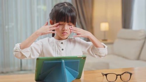 Young Girl Uses Tablet Device with Glasses