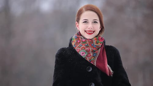 Beautiful redhead woman in the winter park.