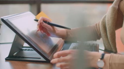 Woman Drawing on Graphics Tablet in Modern Office