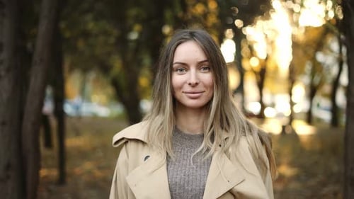 Woman Smiling in Autumn Park at Sunset