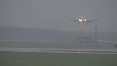 The plane landing on a rainy evening
