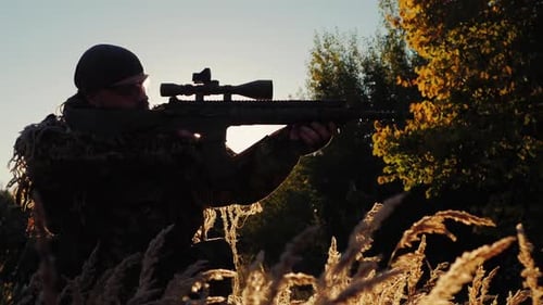 Soldier Airsoft Aim at an Optical Sight Sniper Rifle