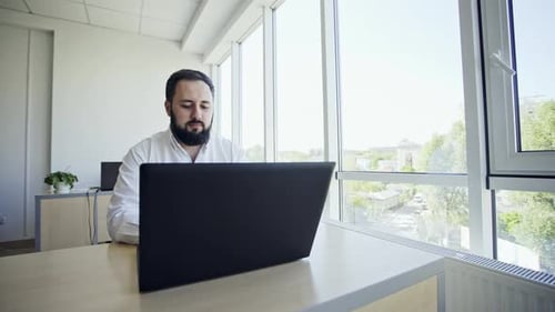 Casual Worker Using Laptop in Office