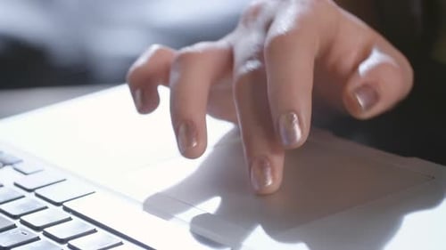 Woman's Hand Using Laptop Trackpad