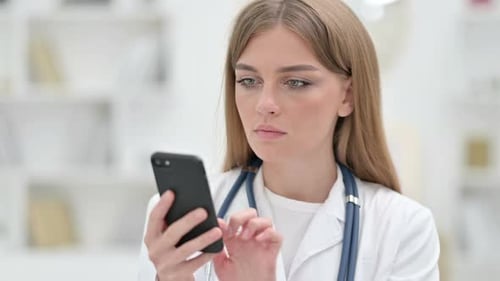 Female Doctor Using Smartphone in Clinic