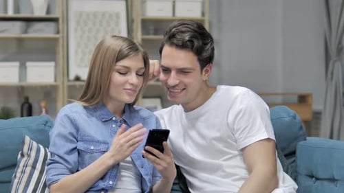 Young Couple Using Smartphone Together at Home